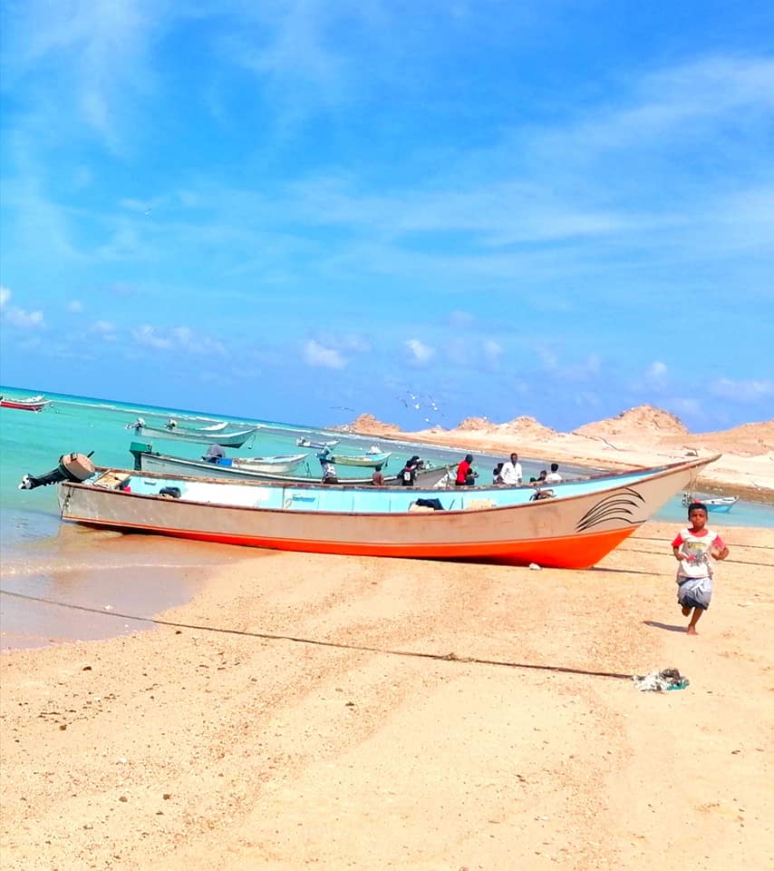 قوارب صيد، وطفل سقطرى يركض باتجاه شيء ما ليس أنا على ما أعتقد- شاطي قلنسية